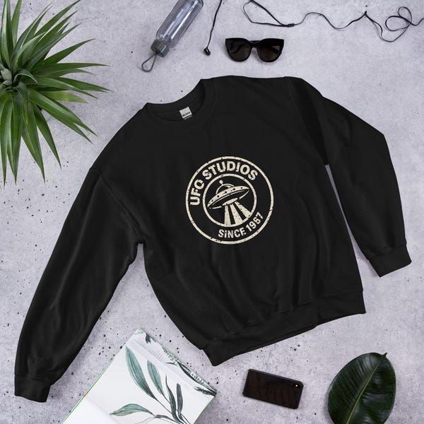 Black UFO Studios crewneck sweatshirt with distressed circular flying saucer seal
